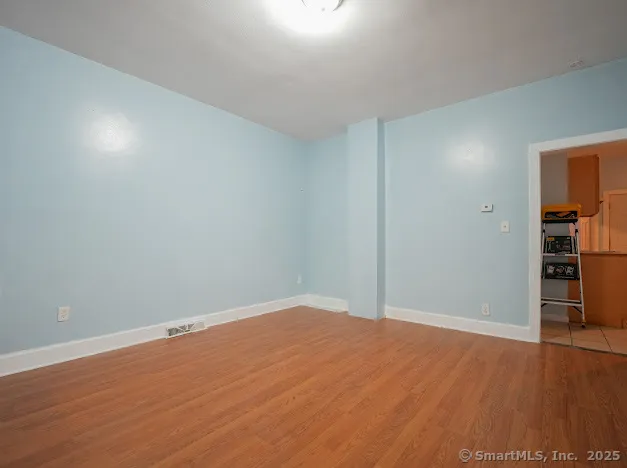 a view of empty room with wooden floor