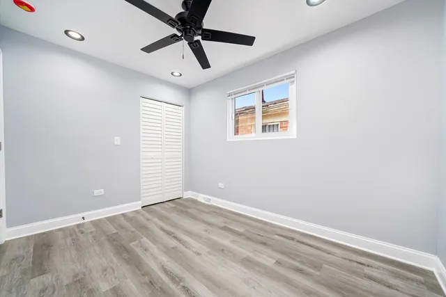 an empty room with a window and a fan