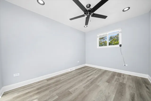 an empty room with a window and a fan