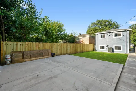 a view of a house with a yard and wooden fence