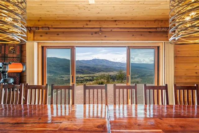 a kitchen with stainless steel appliances granite countertop a stove a sink dishwasher and a dining table with wooden floor