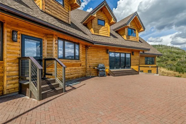 front view of a house with barbeque and wooden fence