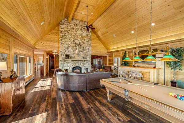 a living room with furniture a fireplace and large windows