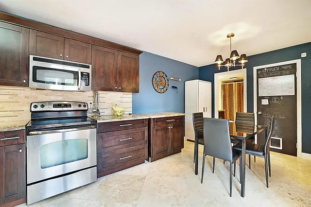 a kitchen with stainless steel appliances granite countertop wooden cabinets a stove top oven a sink and dishwasher