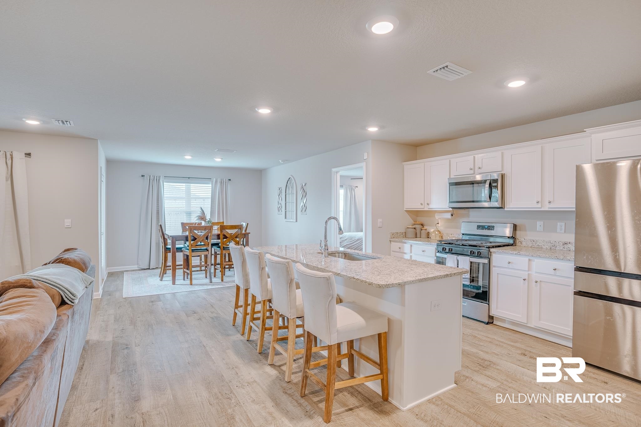 8242 Sycamore Way Semmes, AL 36575 - Photo 6 of 43 Kitchen with stainless steel appliances, a center island with sink, a kitchen breakfast bar, light wood-style floors, and recessed lighting