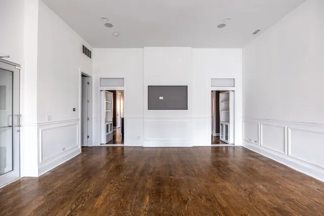 a view of a big room with wooden floor and windows