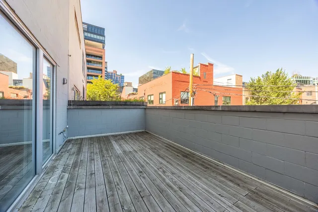 a view of a balcony with wooden floor and fence