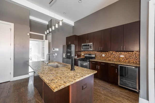 a kitchen with stainless steel appliances granite countertop a sink stove and refrigerator