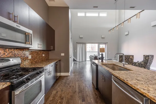 a kitchen with granite countertop a sink stainless steel appliances and cabinets