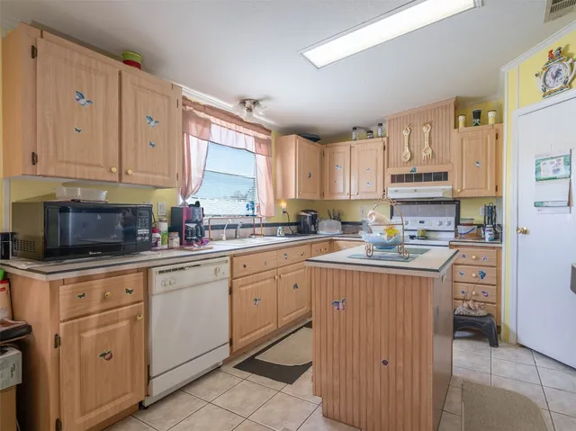 a kitchen with cabinets appliances a sink and a window