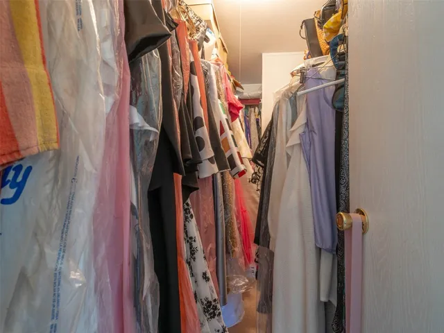 a view of walk in closet with clothes