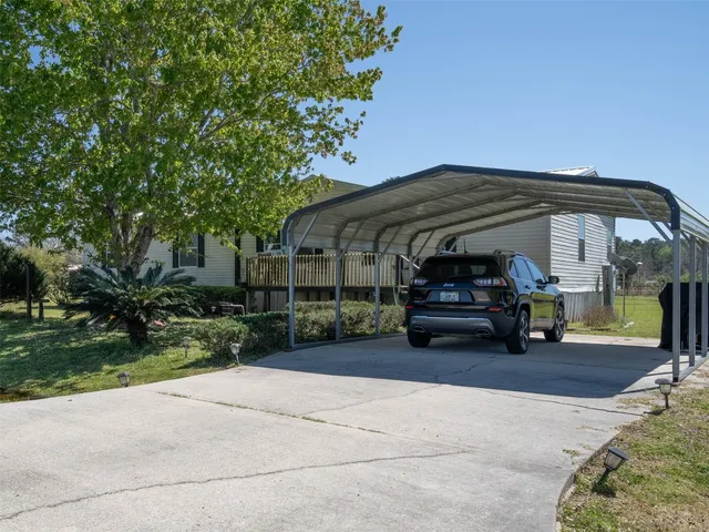 a view of a car park in front of house and trees