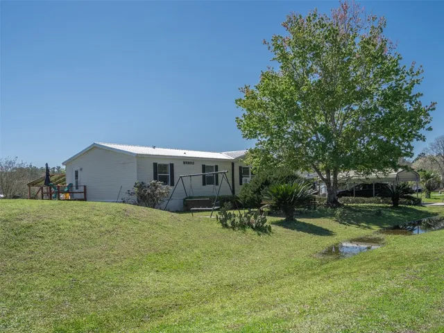 a view of a house with a yard and sitting area