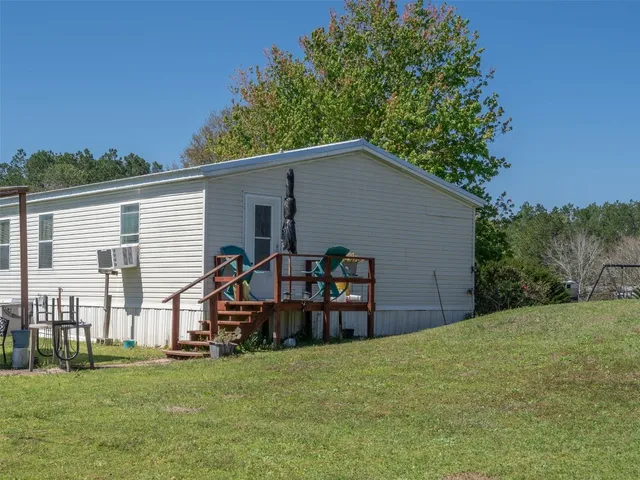 a view of a house with backyard and trees