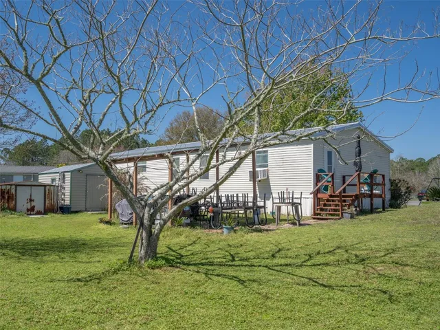 a view of a house with backyard and sitting area