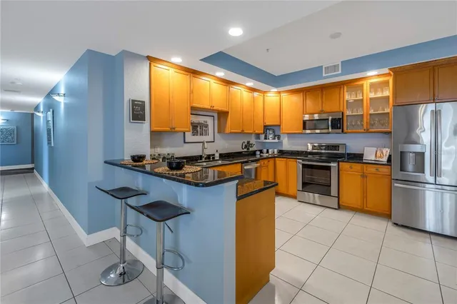 a kitchen with stainless steel appliances granite countertop a stove a sink a microwave and a refrigerator