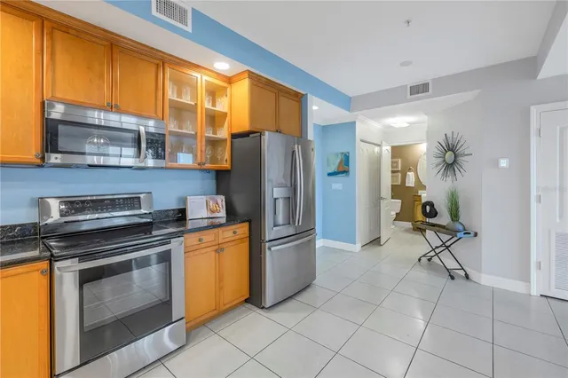 a kitchen with stainless steel appliances granite countertop a refrigerator and a stove
