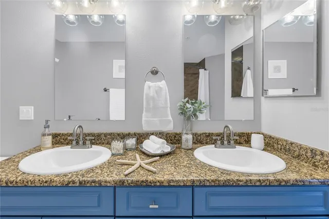 a bathroom with double vanity sinks and a mirror