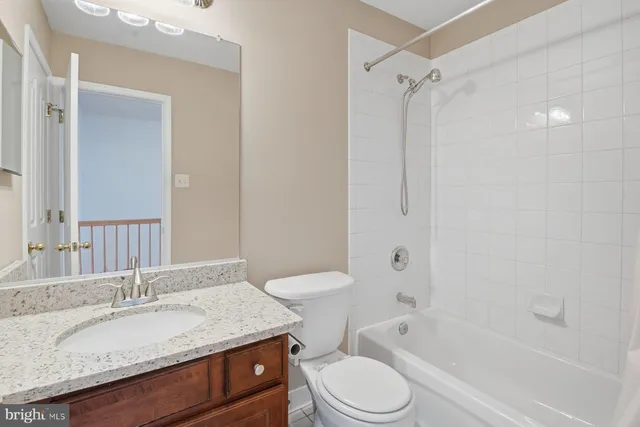 a bathroom with a granite countertop sink toilet a shower and a mirror