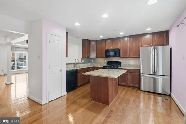 a kitchen with a refrigerator a stove top oven a sink and a center island