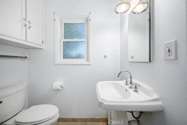 a bathroom with a sink a toilet and mirror