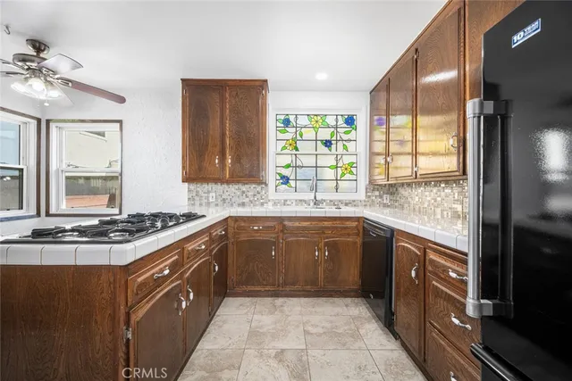 a large kitchen with granite countertop a stove a sink dishwasher and a refrigerator