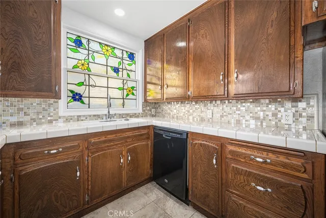 a kitchen with stainless steel appliances granite countertop wooden cabinets a sink and a window