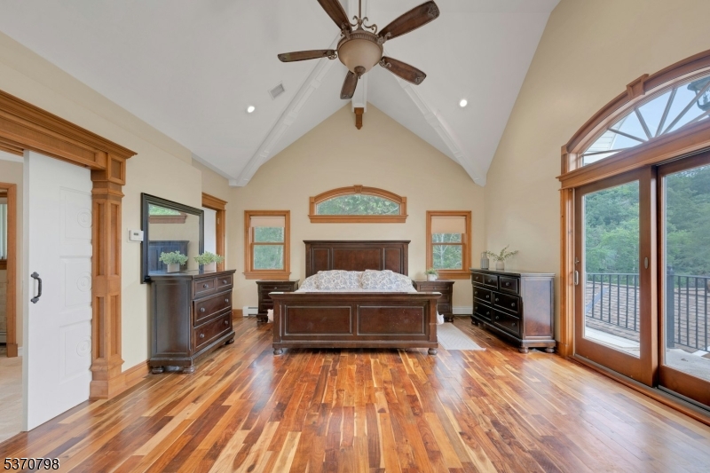 656 Lakeside Avenue Hopatcong, NJ 07821 - Photo 22 of 36 a spacious bedroom with a bed and a chandelier