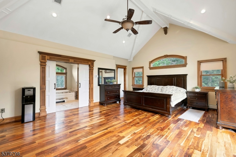 656 Lakeside Avenue Hopatcong, NJ 07821 - Photo 23 of 36 a bedroom with a large bed a chandelier and dresser