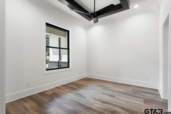 a view of a hallway view with wooden floor and a living room