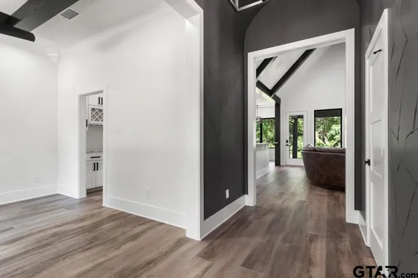 a large kitchen with granite countertop a large stove a sink dishwasher and white cabinets with wooden floor