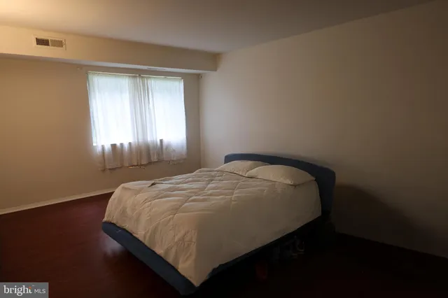 a bed sitting in a bedroom next to a window