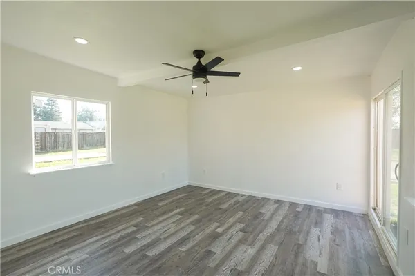 an empty room with a window and a ceiling fan