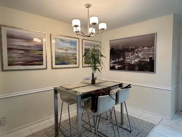 a view of a dining room with furniture a chandelier and wooden floor
