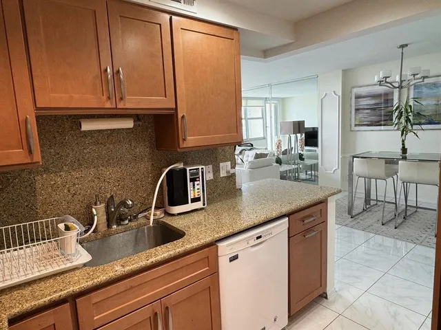 a kitchen with granite countertop a sink a stove and cabinets