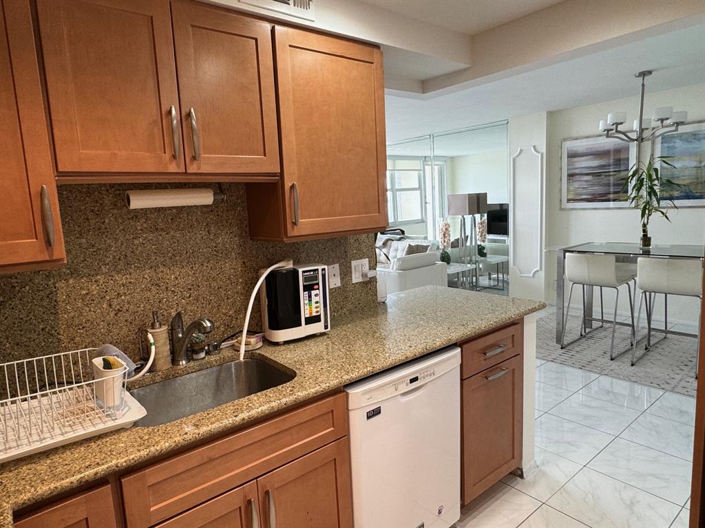 305 North Pompano Beach Boulevard, Unit 1006 Pompano Beach, FL 33062 - Photo 2 of 42 a kitchen with granite countertop a sink a stove and cabinets