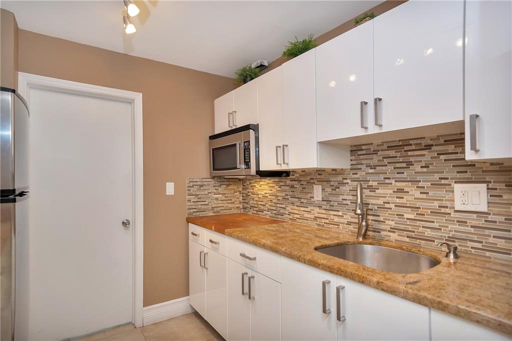 305 North Pompano Beach Boulevard, Unit 1006 Pompano Beach, FL 33062 - Photo 26 of 42 a kitchen with stainless steel appliances granite countertop a sink and a refrigerator