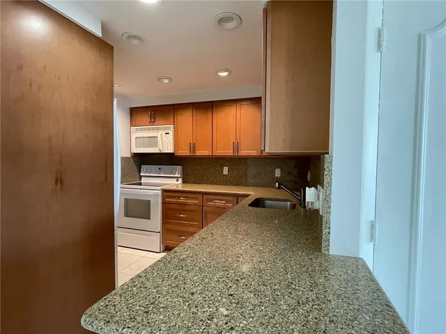 a kitchen with granite countertop a stove and cabinets