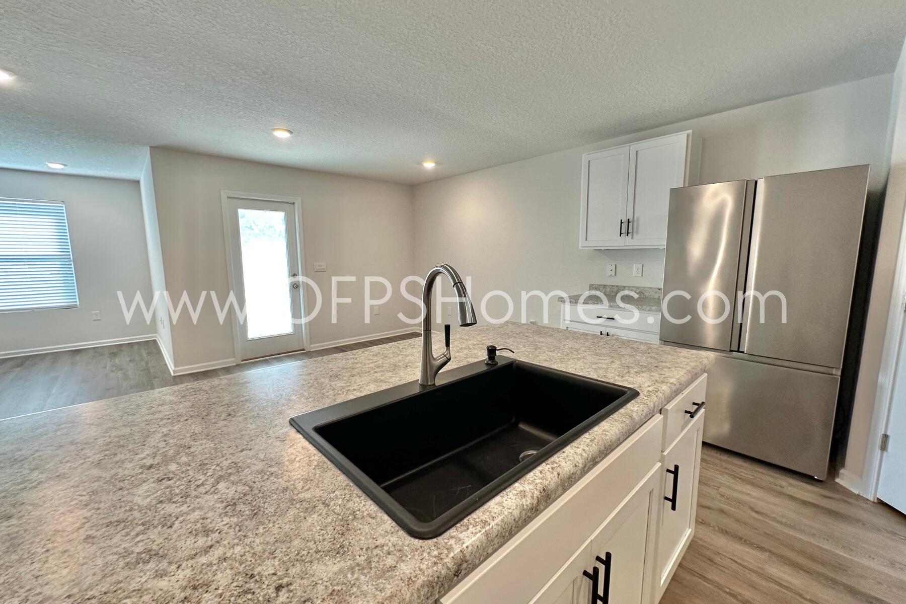 3582 Sugar Maple Lane Crestview, FL 32539 - Photo 16 of 33 a kitchen with a sink a refrigerator and a stove top oven