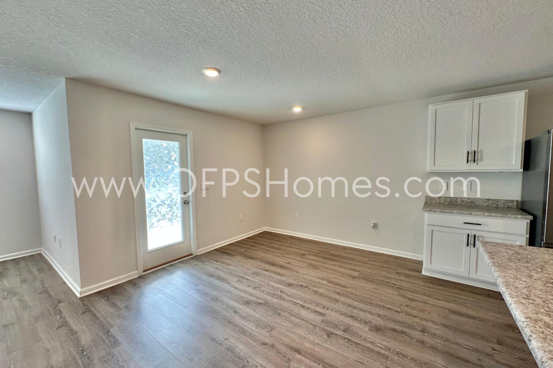 3582 Sugar Maple Lane Crestview, FL 32539 - Photo 19 of 33 a view of a kitchen with granite countertop white cabinets and wooden floor
