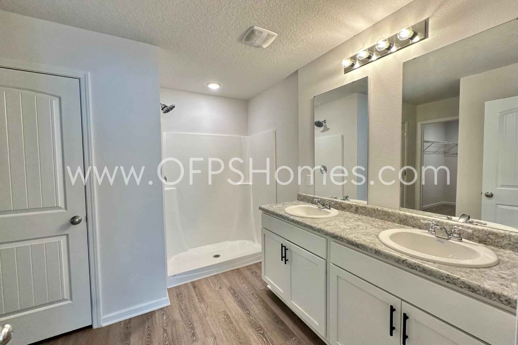 3582 Sugar Maple Lane Crestview, FL 32539 - Photo 28 of 33 a bathroom with a granite countertop sink a mirror and a shower