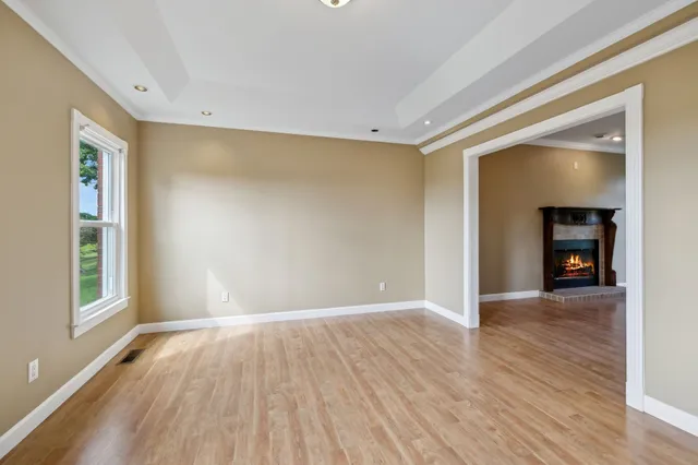 a view of a hallway with wooden floor and a bathroom