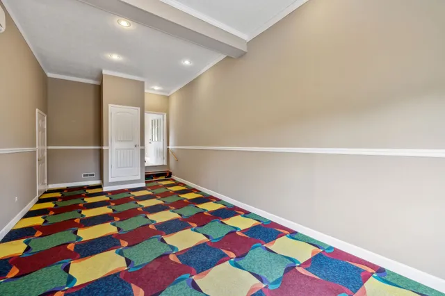 a view of a big room with a ceiling fan and entryway