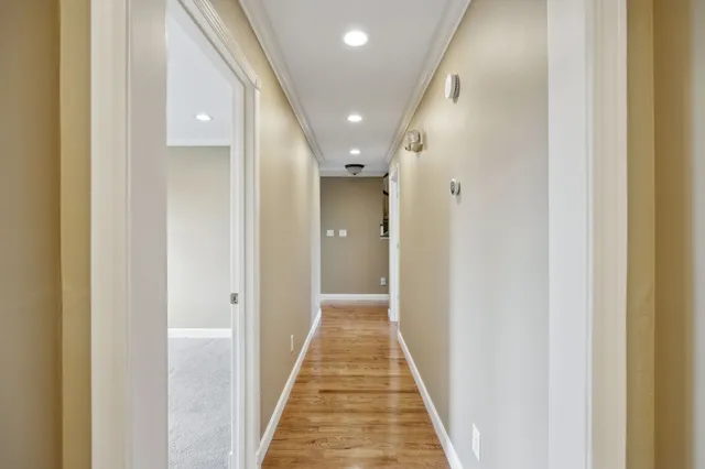a spacious bathroom with a double vanity sink a large mirror and a bathtub