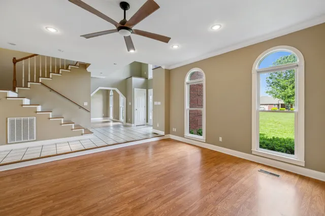 a view of an empty room with a fireplace and window