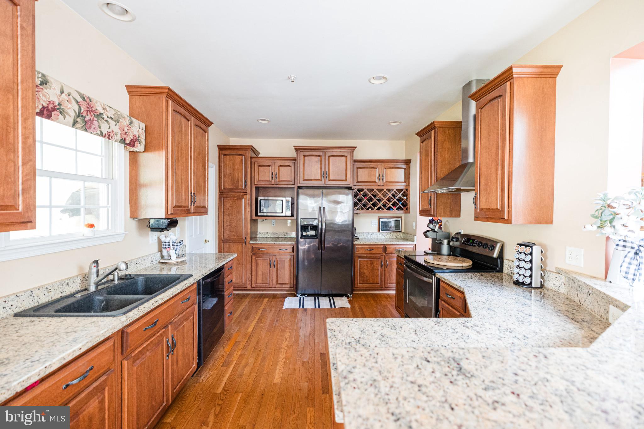 2561 Cedar Ridge Drive Westminster, MD 21158 - Photo 2 of 38 a large kitchen with stainless steel appliances granite countertop a stove a sink dishwasher and cabinets with wooden floor