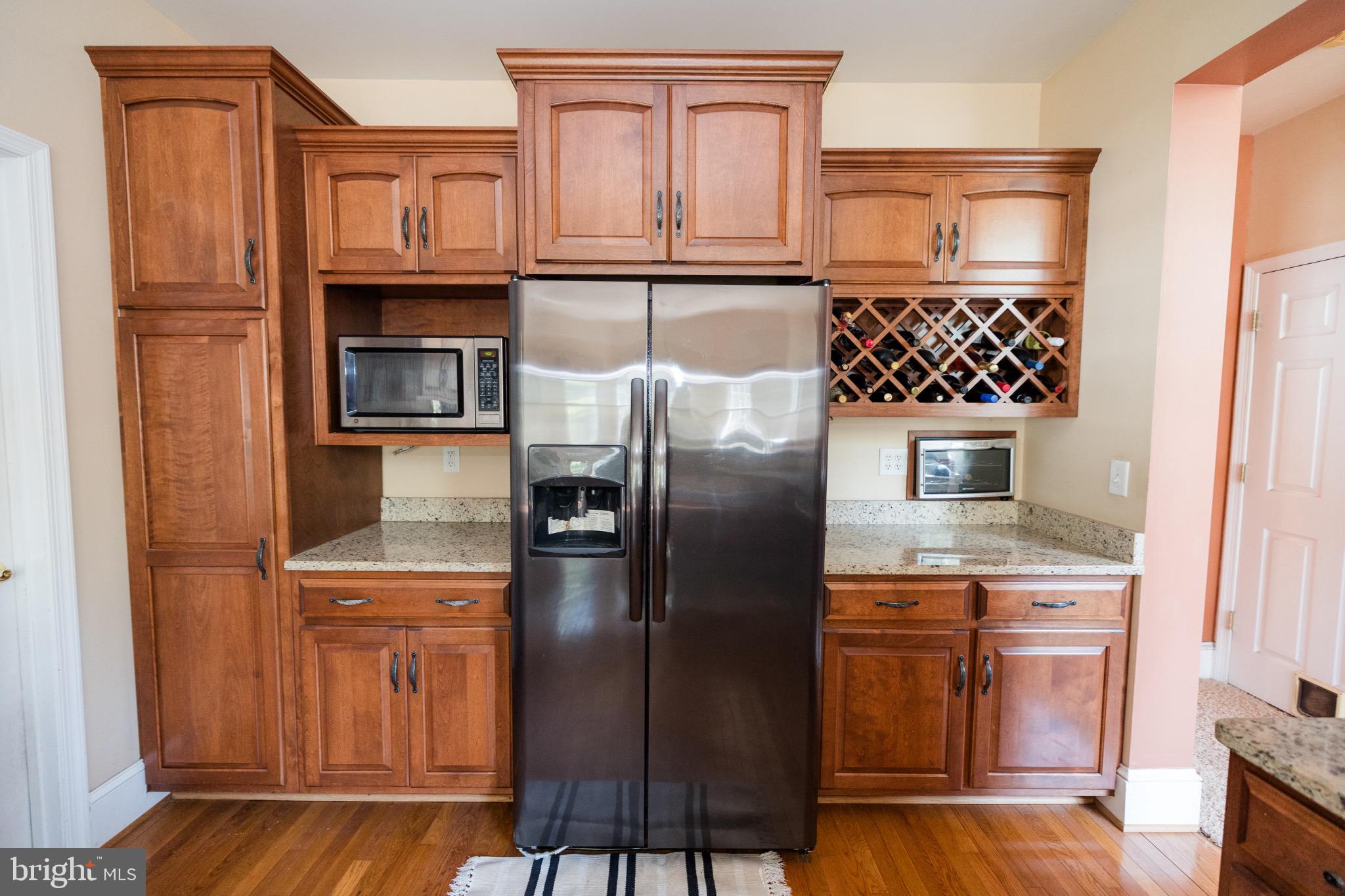 2561 Cedar Ridge Drive Westminster, MD 21158 - Photo 22 of 38 a kitchen with stainless steel appliances granite countertop a refrigerator a stove and a sink with wooden cabinets