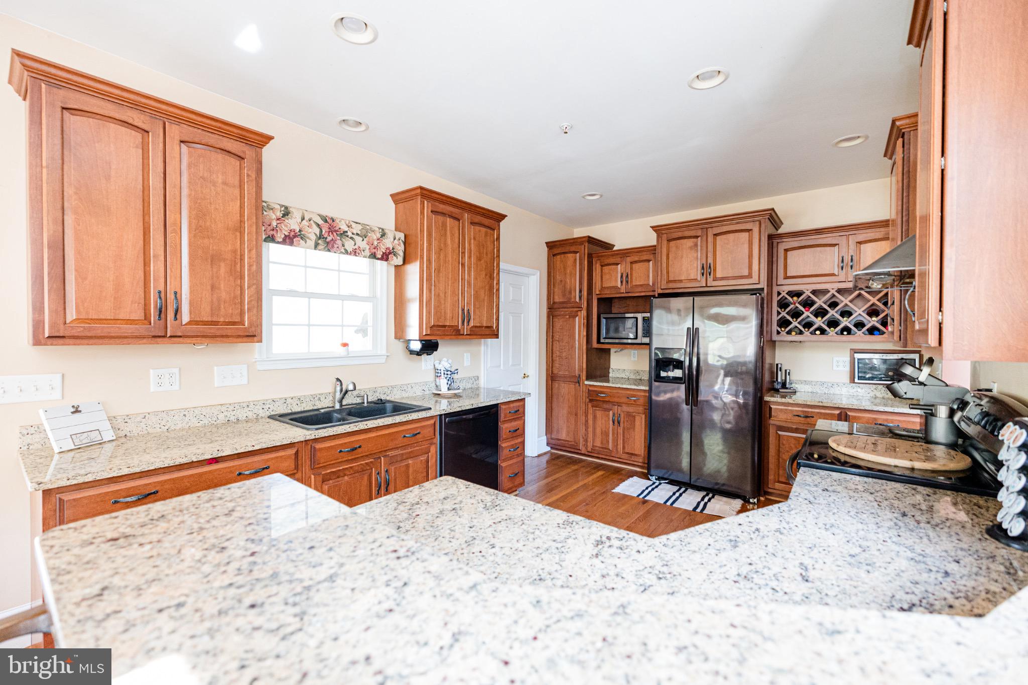 2561 Cedar Ridge Drive Westminster, MD 21158 - Photo 3 of 38 a kitchen with stainless steel appliances kitchen island granite countertop a sink stove and refrigerator