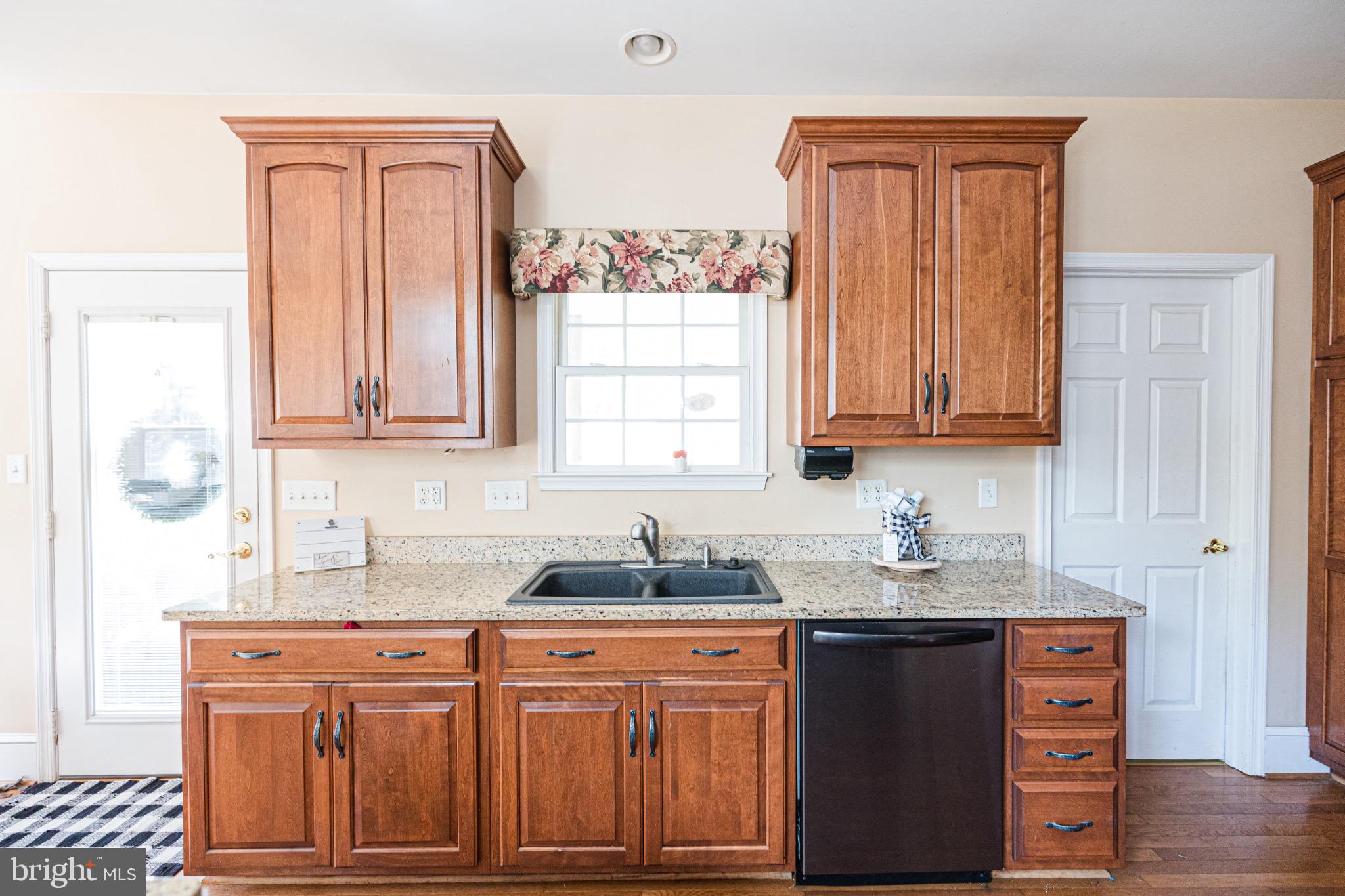 2561 Cedar Ridge Drive Westminster, MD 21158 - Photo 4 of 38 a kitchen with stainless steel appliances granite countertop a sink stove and granite countertops with wooden floor