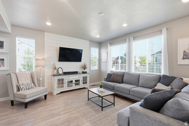3244 West 1670th Street North Provo, UT 84601 - Photo 9 of 56 Living area featuring light wood-finish flooring, recessed lighting, and multiple windows with blinds